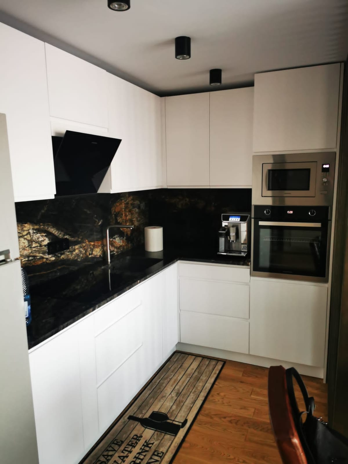Bucătărie finisată complet cu mobilier alb și blat din piatră